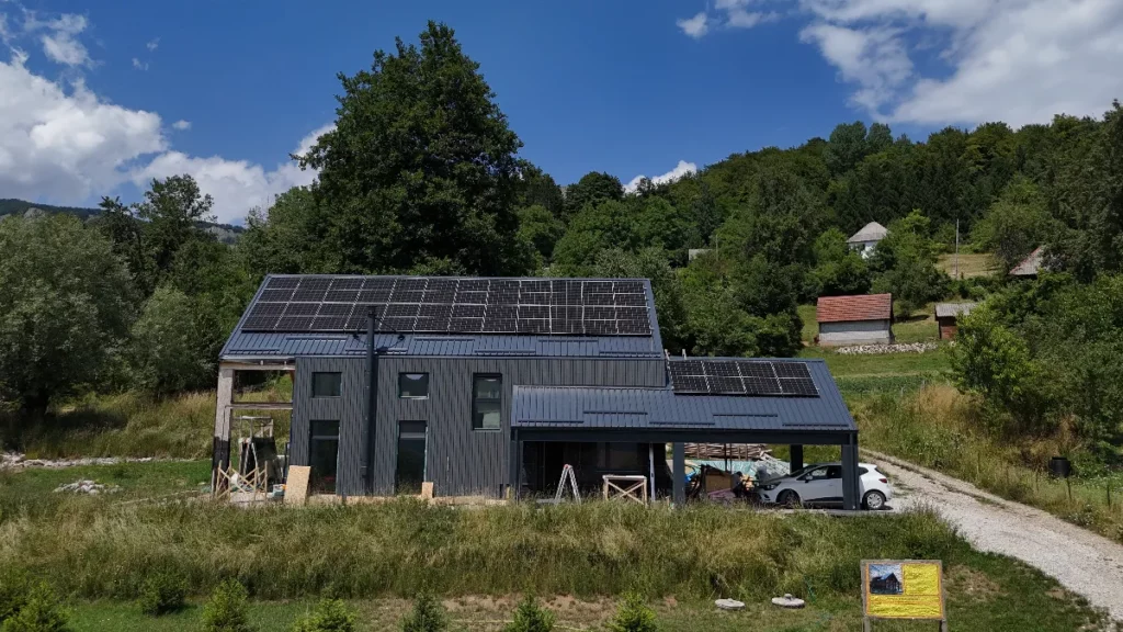 Kuća sa solarnim panelima na krovu u prirodi.