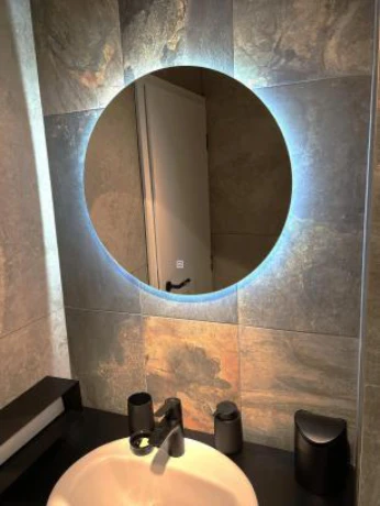 Modern bathroom sink with round illuminated mirror
